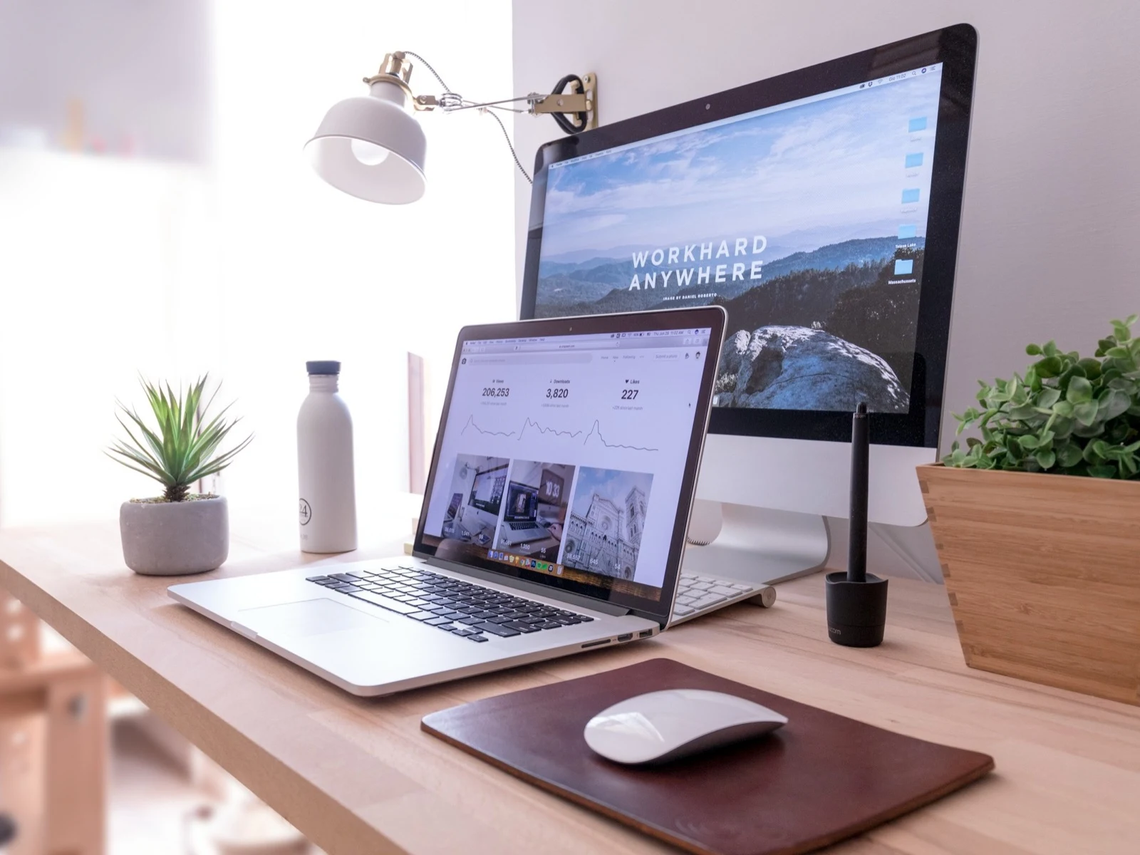 Arbeitsplatz mit Laptop und Monitor, auf beiden Bildschirmen läuft eine andere Anwendung